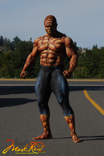 A man in a flexing pose body painted to accentuate his muscles